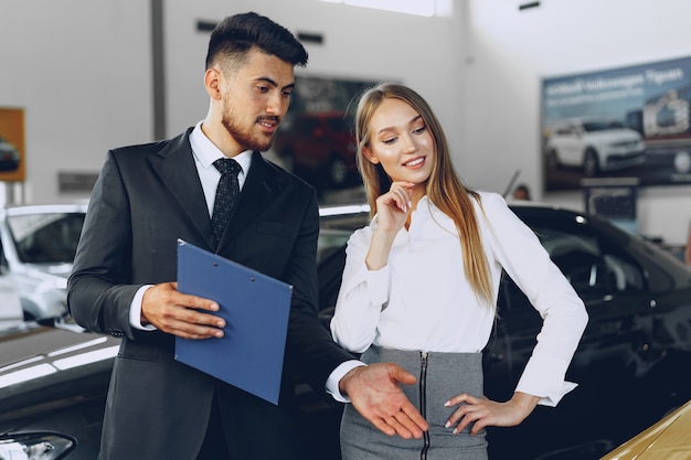 Concesionario de automóviles hombre mostrando a una mujer comprador un coche nuevo