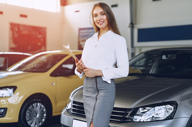 Concesionario de coches joven hermosa feliz en la sala de exposición de cerca