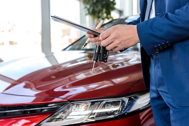 Concesionario sosteniendo las llaves del coche nuevo de cerca