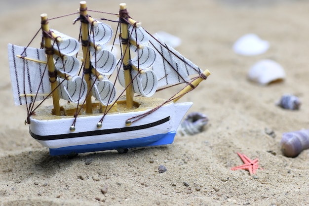 Foto concha de areia e vela no mar