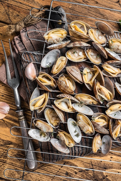 Conchas cocidas Almejas vongole a la parrilla con ajo y romero Fondo de madera Vista superior