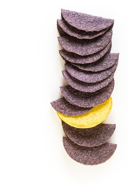 Conchas de taco de milho azuis e amarelas em um fundo branco.