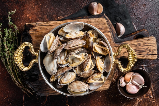 Conchas de vinho branco de alho Amêijoas vongole em uma frigideira com ervas Fundo escuro Vista superior