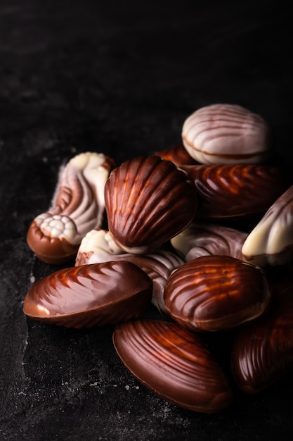 Conchas do mar de chocolate belga em uma mesa preta