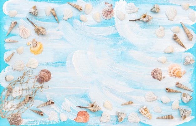 Conchas do mar sobre fundo azul de madeira. Quadro plano com espaço de cópia