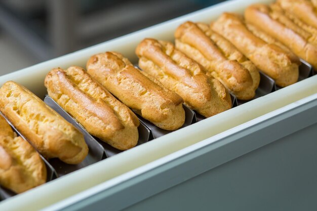 Conchas de eclair amarillas Línea de transporte estrecha con eclairs Calidad sobre cantidad Producto que se vende bien