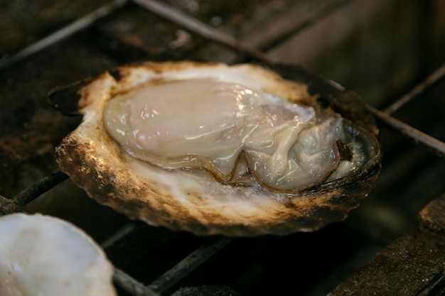 Conchas de mariscos y pescado cocinados en una parrilla en el mercado de pescado de Osaka, Japón