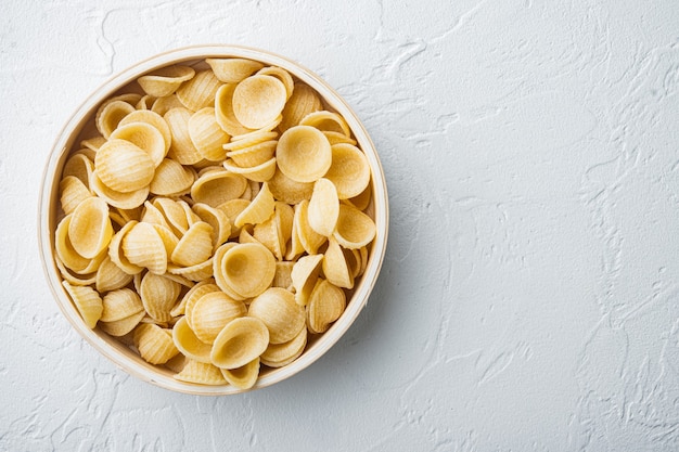 Conchas de pasta seca en un tazón, plano