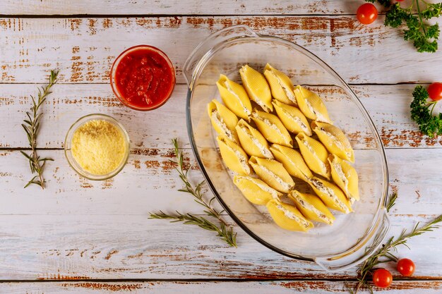 Conchas rellenas de pasta con ricotta, queso parmesano y salsa