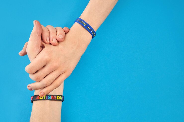 Foto concienciación sobre el autismo autismo padre sosteniendo de la mano a su hijo autista con tengo pulsera de autismo