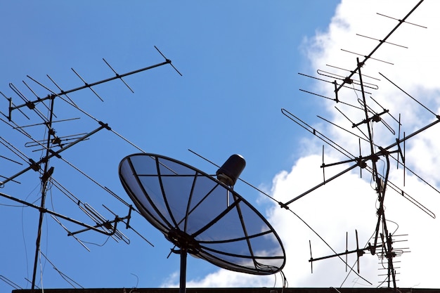 Concpetual vom Satelliten und von der Antenne auf blauem Himmel