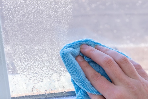 Condensação nas janelas no inverno, limpando com um pano seco