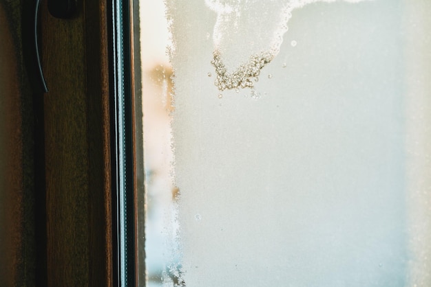 Condensación congelada en el vidrio interior de la ventana Vapor helado y rocío en el vidrio durante el invierno