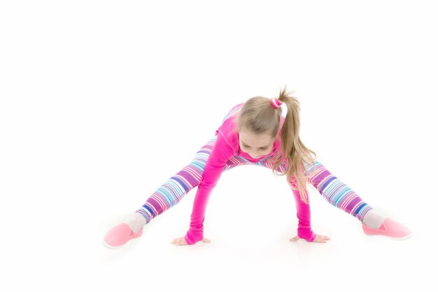 Condición física y salud. Niño en ropa deportiva rosa. Entrenamiento de niña pequeña aislada sobre fondo blanco. Deporte y éxito. Educación y energía, deporte