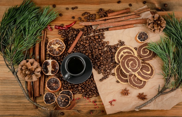 Condimente la galleta de canela con relleno de chocolate, café y nueces en la vista superior del fondo de madera. Galletas blandas redondas marrones y blancas, galletas de melaza de jengibre, galleta de jengibre navideña