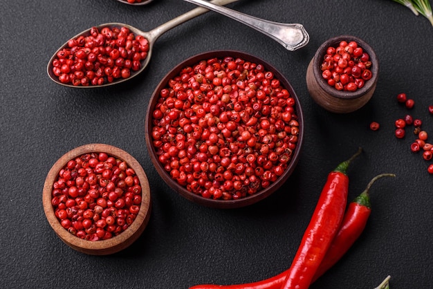 Condimente los guisantes de pimienta de color rojo o rosa en un tazón de madera