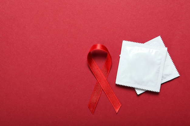 Condones y cinta roja que simboliza el día mundial del sida