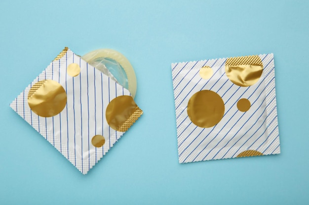 Condones sobre fondo azul Un uso de condones para reducir la probabilidad de embarazo o enfermedades de transmisión sexual
