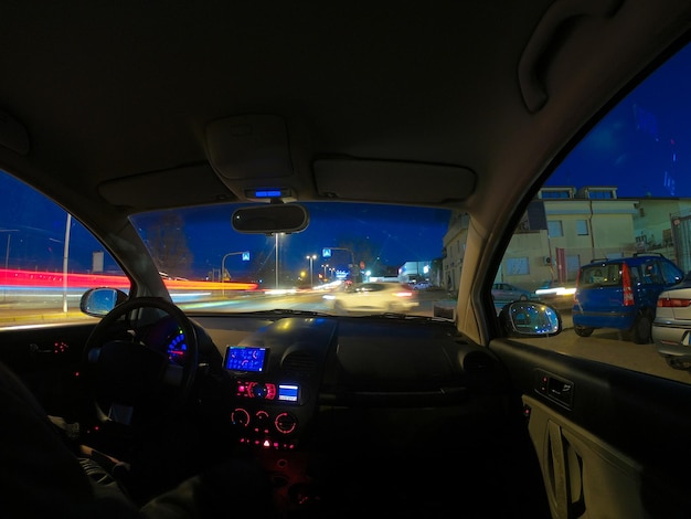 Conduce el coche en la ciudad por la noche.