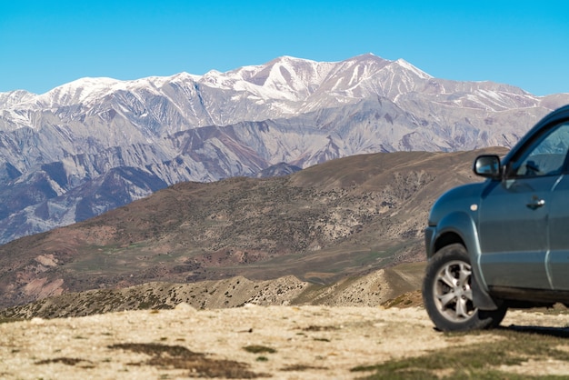 Conduce un coche hasta los picos nevados de las montañas.