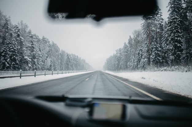 Conducir por una carretera nevada en invierno en un coche vista interior