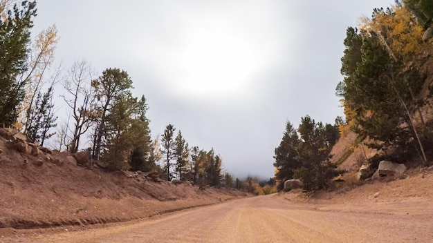 Conducir por pequeños caminos de tierra de montaña desde Colorado Springs hasta Cripple Creek en otoño.