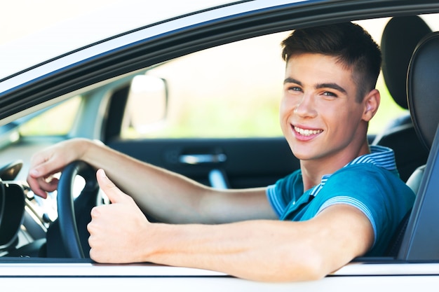 Conductor adolescente conduciendo joven coche