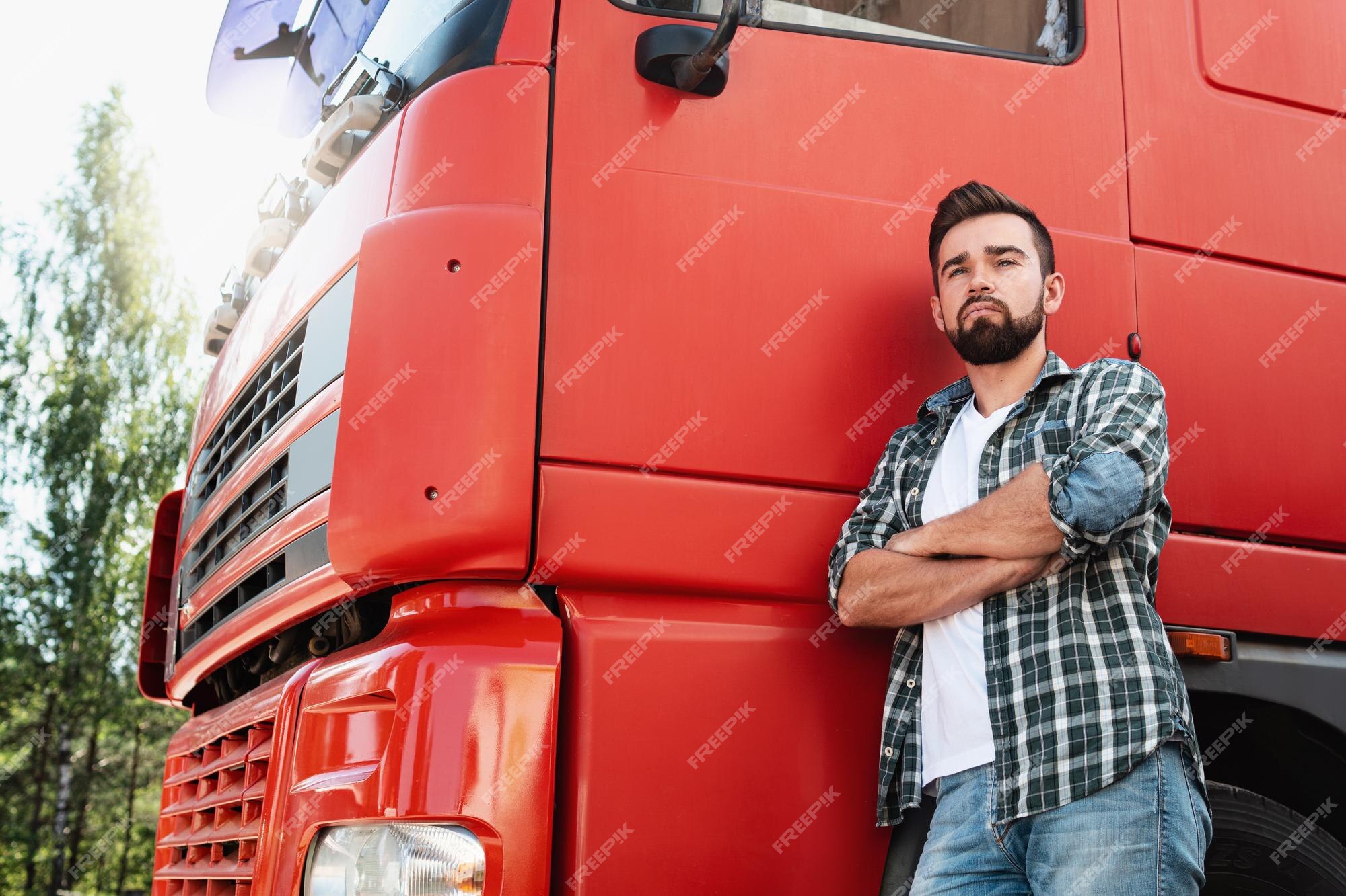 La ciudad Monet ligero Conductor de camión masculino de pie junto a su camión de carga rojo | Foto  Premium