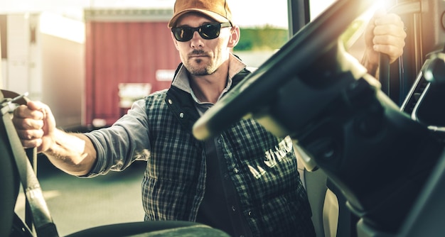 Conductor de camión y su moderno camión tractor preparándose para el próximo destino