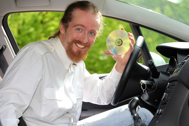 Conductor con CD reproduciendo música en el coche.