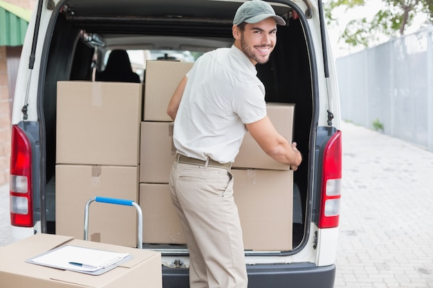 Conductor de entrega cargando su camioneta con cajas