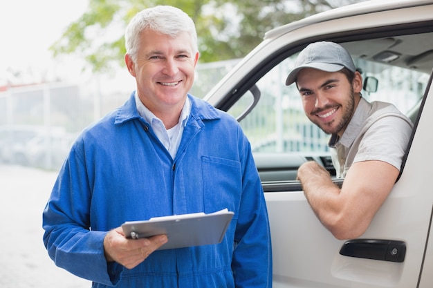 Conductor de entrega sonriendo a la cámara con el cliente