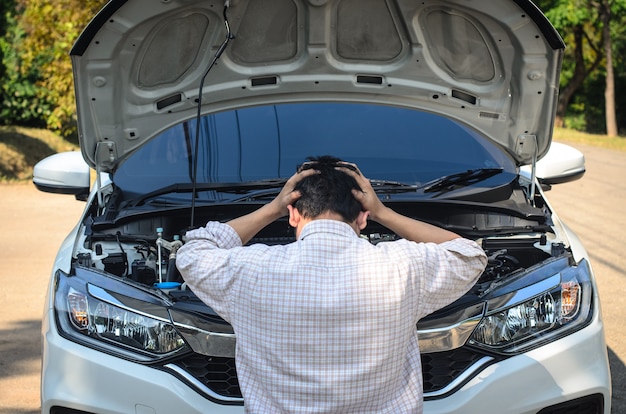 El conductor está estresado con el coche que no arranca.