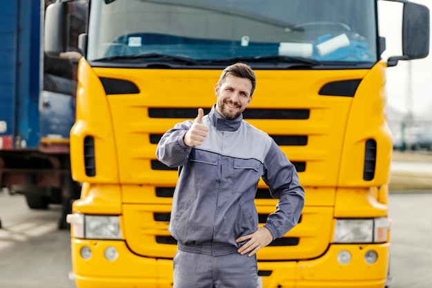 Un conductor feliz está dando su visto bueno por el envío a tiempo mientras está parado frente al camión