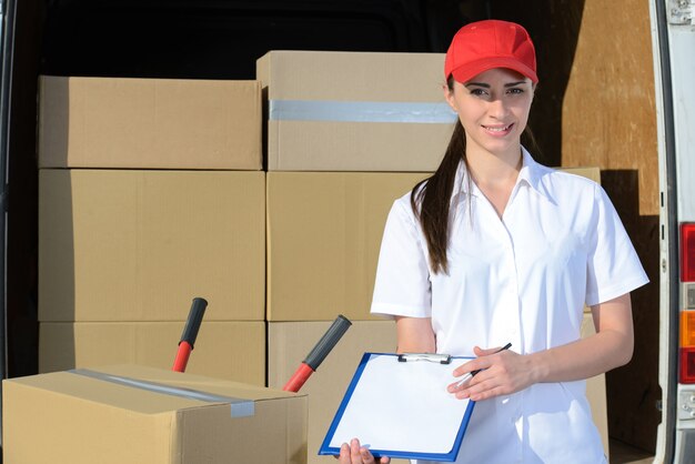 Conductor femenino de la entrega con el tablero y la caja.