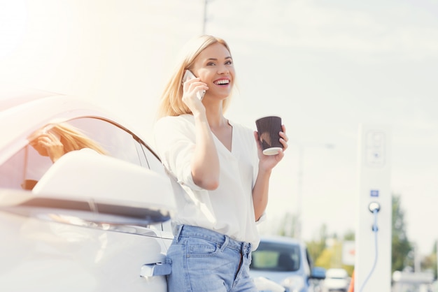 Conductor femenino feliz joven que habla en el teléfono