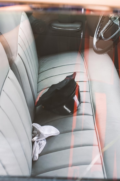 Un conductor con gorra y guantes en el asiento delantero de un buick