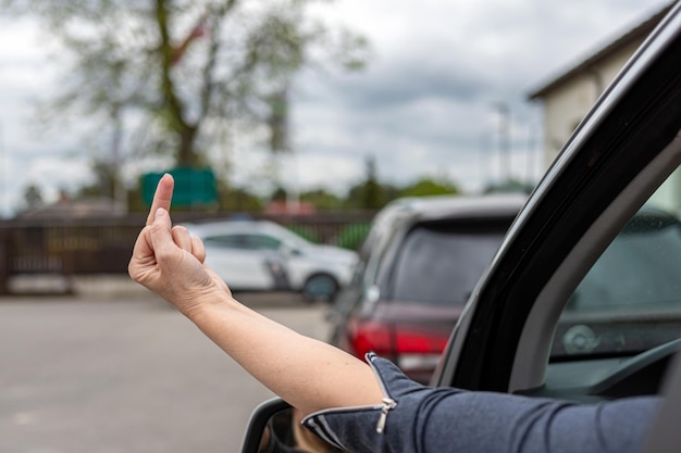 Foto el conductor grosero y furioso le da el dedo medio al coche detrás de la mujer muestra un gesto obsceno de un coche