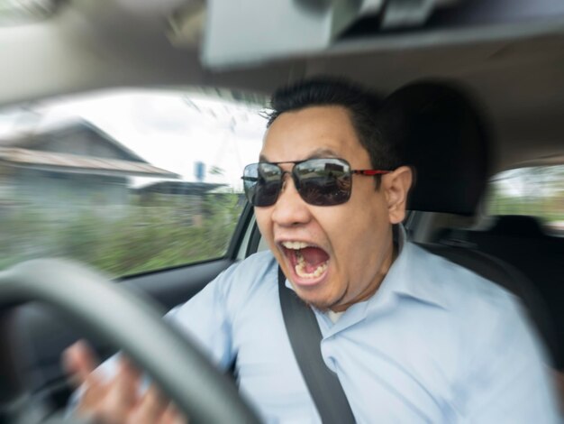 Foto conductor masculino asiático conmocionado y en pánico accidente acercado concepto de desenfocado de movimiento borroso