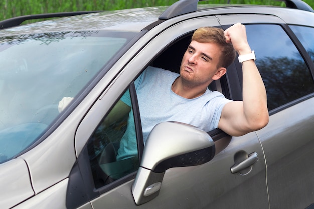 Conductor masculino enojado conduciendo el automóvil