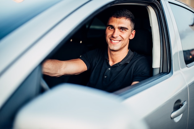 Conductor masculino feliz en coche, concepto de publicidad. Conducción de automóviles