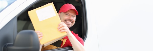 Foto conductor de mensajería macho sonriente tiene correo en sus manos