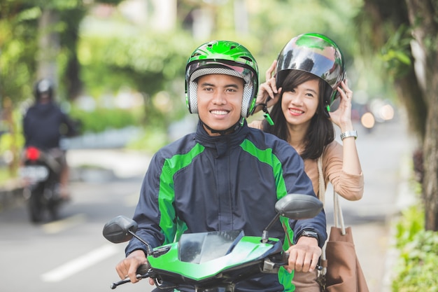 Conductor de moto comercial que lleva a su pasajero