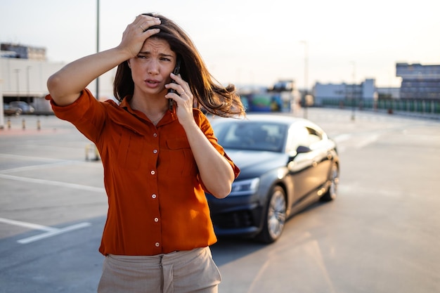 Conductor mujer que usa teléfono móvil durante una avería del automóvil con problemas o un automóvil roto en la carretera Concepto de servicio y mantenimiento de seguros de vehículos