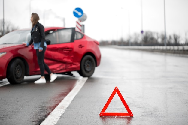 Conductor sentado al lado de la carretera después de un accidente de tráfico