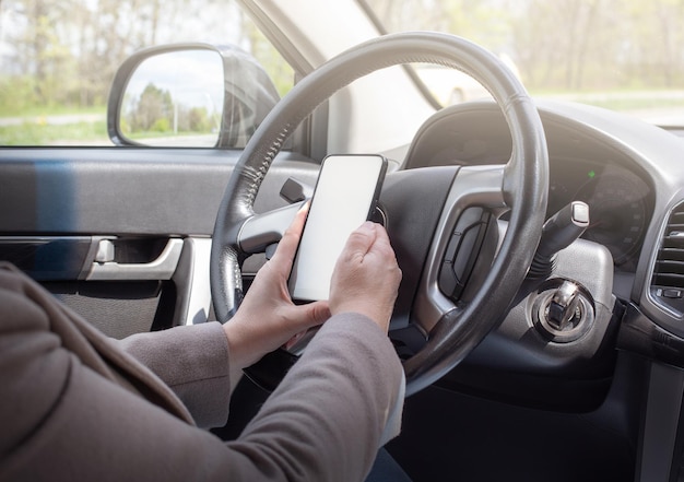 Conductora joven con pantalla táctil smartphone y navegación gps en un coche