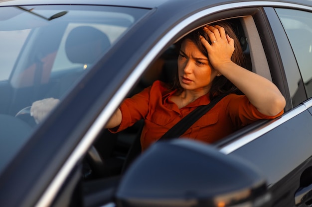 Foto una conductora nerviosa sentada al volante tiene una expresión preocupada porque tiene miedo de conducir sola por primera vez una mujer asustada tiene un accidente automovilístico en la carretera la gente conduce problemas con el transporte