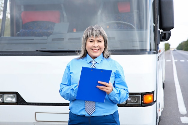 Conductora de pie delante del autobús