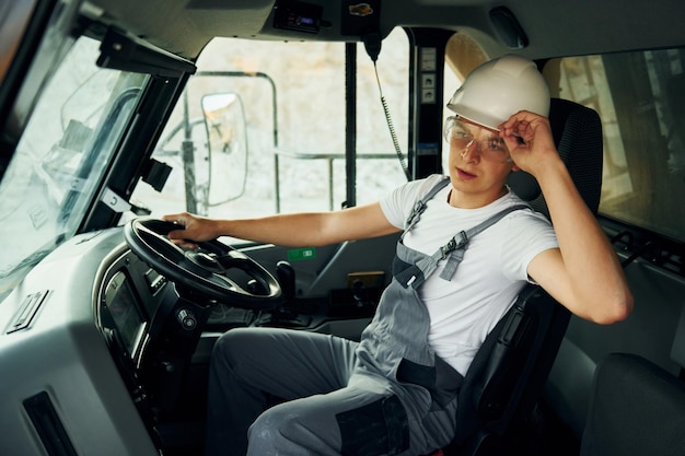 Foto conduzindo o trabalhador de transporte em uniforme profissional está no poço de empréstimo durante o dia