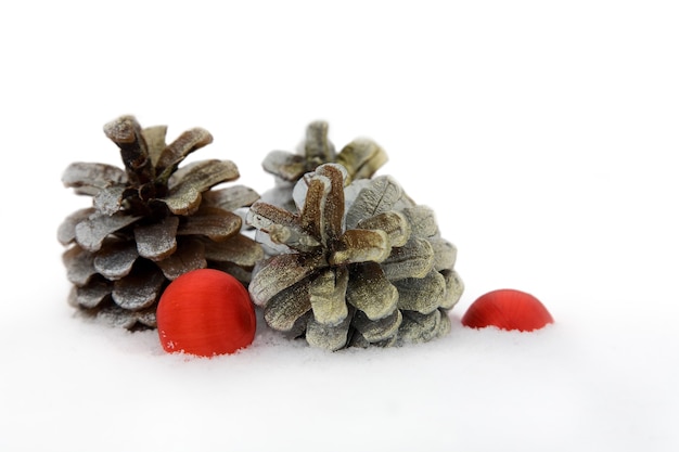 Cone de abeto e bola de Natal em fundo de neve